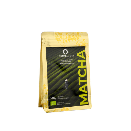 A 100g stand-up pouch of Artemony Matcha loose-leaf tea, featuring a black central label with a green tea plantation graphic and yellow accents, set against a plain white background.