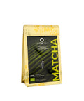 A 100g stand-up pouch of Artemony Matcha loose-leaf tea, featuring a black central label with a green tea plantation graphic and yellow accents, set against a plain white background.