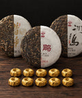 Your Pu-Erh Ritual: three 100 g Sheng tea cakes, each shown half unwrapped, with 10 gold-wrapped Jin ke Shou portions